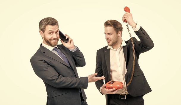 Arbeitgeber mit Smartphone lachen Mitarbeiter mit Retro-Telefon aus - Foto, Bild