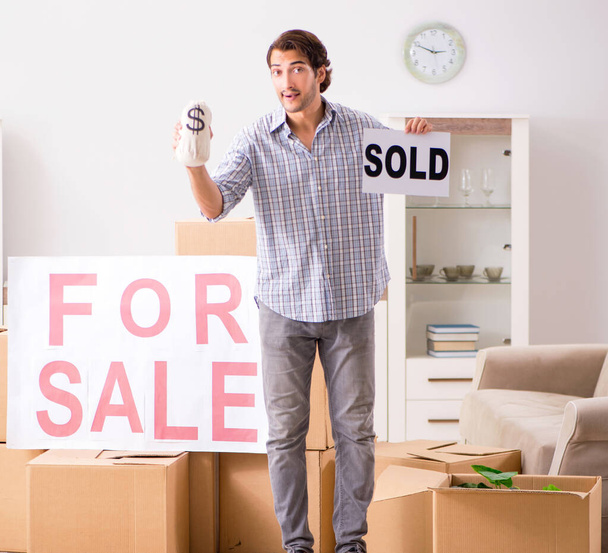 junger Mann bietet Wohnung zum Verkauf an und zieht aus - Foto, Bild
