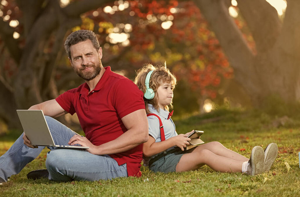 padre e hijo utilizan la tecnología de comunicación moderna en el parque. blog familiar. - Foto, Imagen
