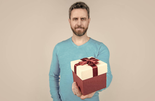 present for womens day. giftbox in hand of successful handsome man. selective focus. - Фото, зображення