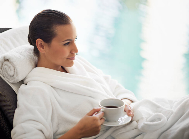 Enjoying her morning coffee. Shot of a young woman drinking a cup of coffee at the day spa. - Foto, Imagem