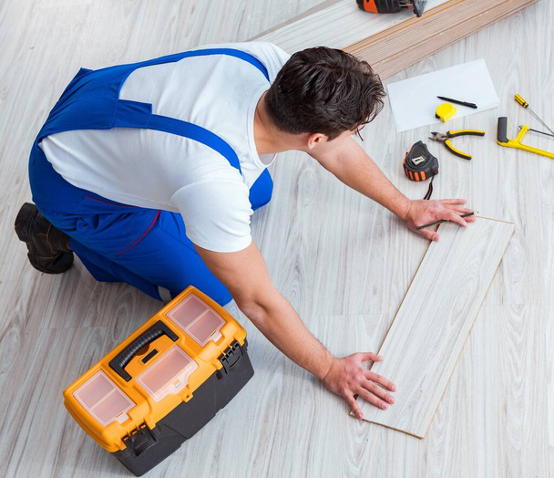 Repairman laying laminate flooring at home - Fotoğraf, Görsel