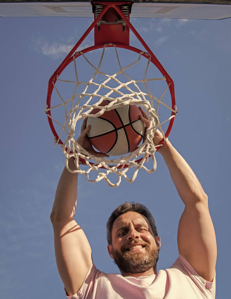 happy man player throw basketball ball through basket, winning - Foto, imagen