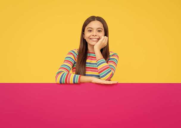 happy teenager girl behind pink paper sheet with empty place for copy space, advertisement - Foto, Bild