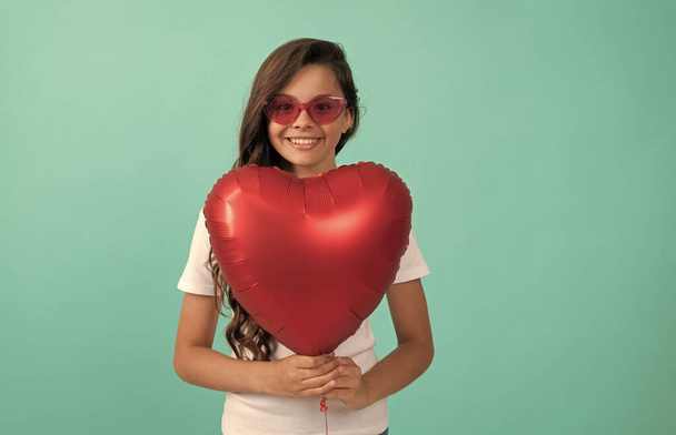 Güneş gözlüklü mutlu çocuk kırmızı kalp parti balonu tut Sevgililer günü aşk sembolü, parti - Fotoğraf, Görsel