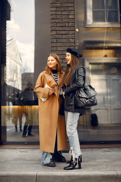 Two female friends in fashion clothes standing on the street - Valokuva, kuva