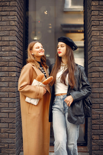 Two female friends in fashion clothes standing on the street - Foto, Bild