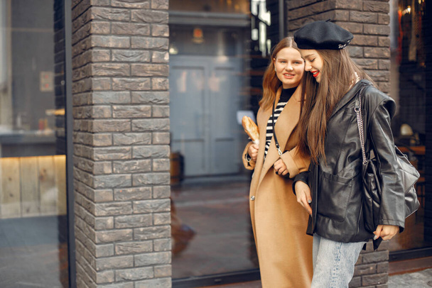 Two female friends in fashion clothes walking on the street - Photo, Image
