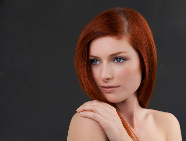 Her beauty is perfection. Studio shot of a gorgeous young redheaded woman against a black background. - Photo, Image