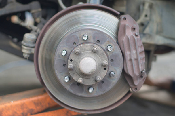 Eje de rueda de coche usado. Imagen borrosa, los frenos de disco tienen desgaste. - Foto, Imagen