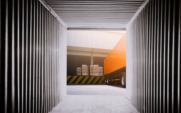 Внутренний вид пустых грузовых контейнеров. Грузовики-трейлеры грузят упаковочные коробки на складе доков. Транспортная логистика грузовых перевозок. - Фото, изображение