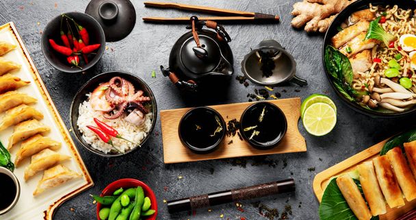 Азиатская еда с различными ингредиентами на темном фоне. Вид сверху. - Фото, изображение