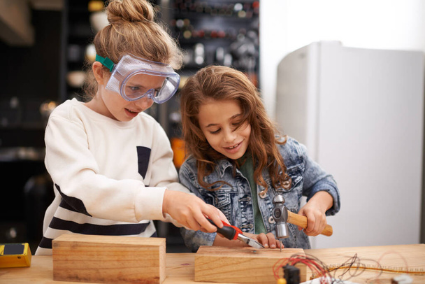 Грати з татами інструменти найкраще. Дві маленькі дівчата зайняті роботою над створенням чогось з інструментами
. - Фото, зображення