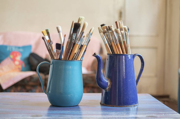 Diversi pennelli professionali nel barattolo di metallo blu su uno sfondo sfocato studio, messa a fuoco selettiva - Foto, immagini