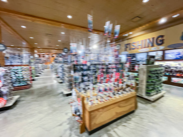 Blurred FISHING text and full of fishing gears, supplies, tackles and equipments at outdoor store near Dallas, Texas, USA. Hobby and recreational accessories on display at sporting goods store - Photo, Image