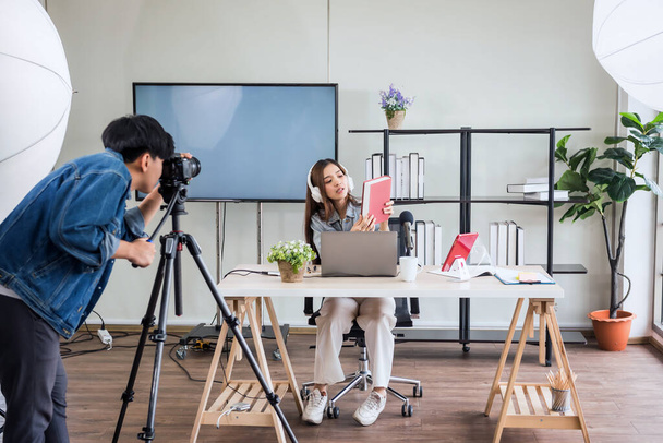 Behind the scene concept. Videographer record footage of young female blogger and streaming live online with studio lighting. broadcasting vlogger. internet influencer. - Foto, Bild