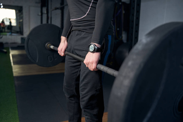 Man having weight training with barbell in gym - Foto, afbeelding