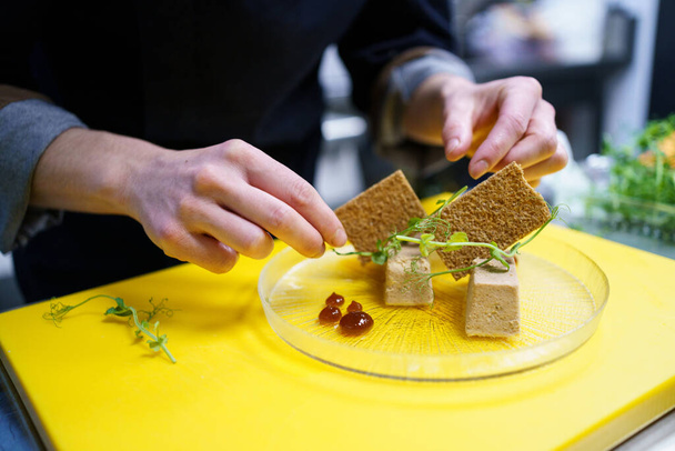 Crop chef placcatura foie micuit con crostini croccanti nel ristorante - Foto, immagini