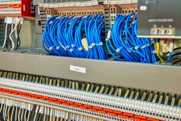 Организованные аккуратные и не грязные электронные провода для обработки сигналов в научной лаборатории. Много соединенных кабелей в розетках - Фото, изображение
