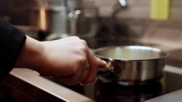 Chef sacude una cacerola en una estufa eléctrica - Imágenes, Vídeo