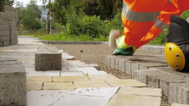 Operaio edile fa nuovo marciapiede marciapiede con mattoni di pietra - Filmati, video