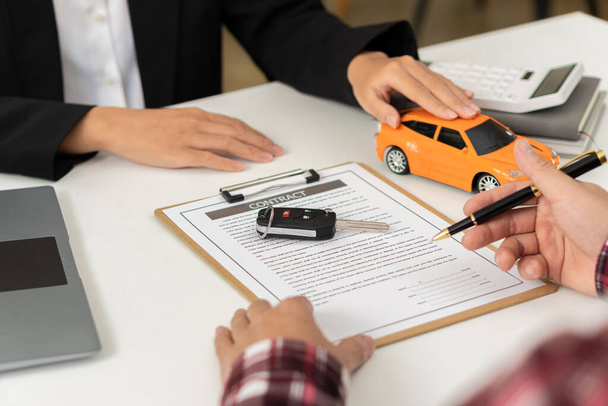 Car dealerships offer car title contracts for interest rates at their office desks. - Fotó, kép
