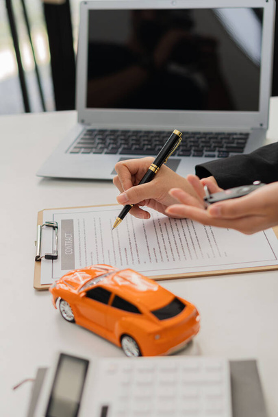 Car dealership offices offer car sales contracts at their desks. - Фото, зображення