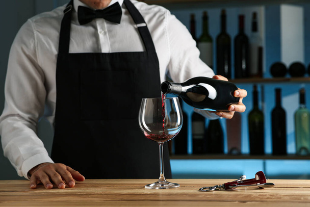 Bartender pouring wine into glass at counter in restaurant, closeup - Foto, Imagem