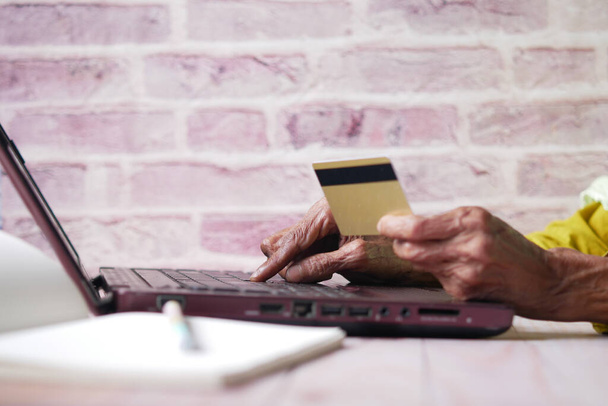 senior women hand holding credit card and using laptop for making payment  - Φωτογραφία, εικόνα