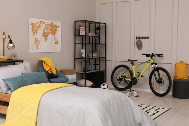 Stylish teenager's room interior with comfortable bed and sports equipment - Valokuva, kuva