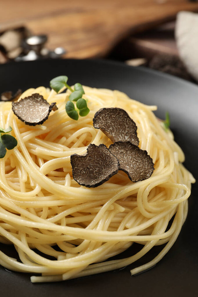 Tasty spaghetti with truffle on black plate, closeup - Photo, image