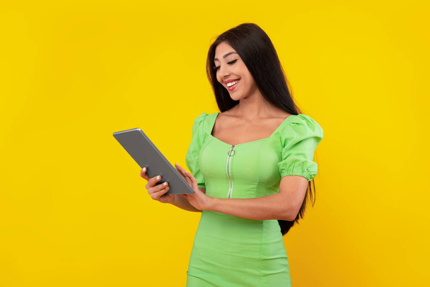 Joyeux jeune femme en utilisant la tablette au studio - Photo, image