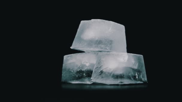 Kwadratowe kostki lodu wirują na czarnym tle - Materiał filmowy, wideo