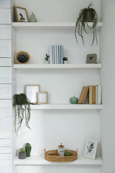 Many shelves with different decor in room. Interior design - Фото, изображение