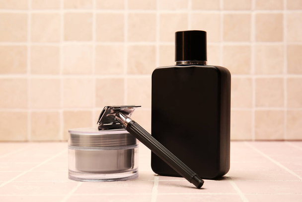 Shaving razor and perfume on tile background - Photo, Image