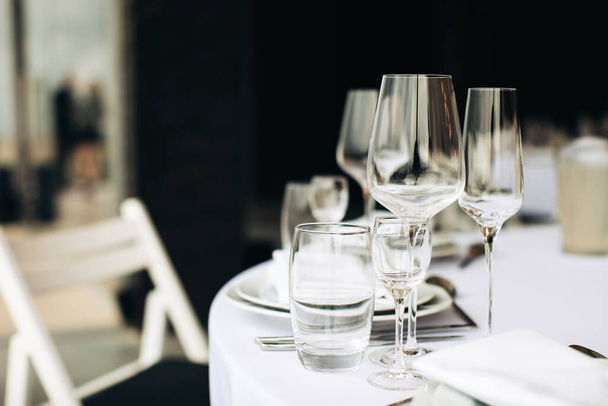 Empty wine glasses on the table for a festive dinner. - Fotó, kép