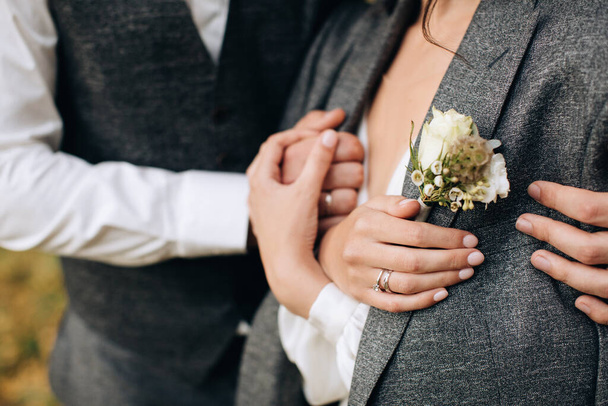 The groom hugs the bride and warms her. Rustic style boutonniere - Foto, Bild