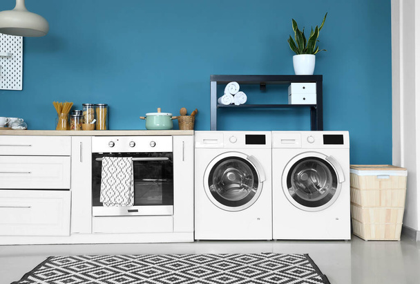 Интерьер стильной кухни с современной стиральной машиной и духовкой - Фото, изображение
