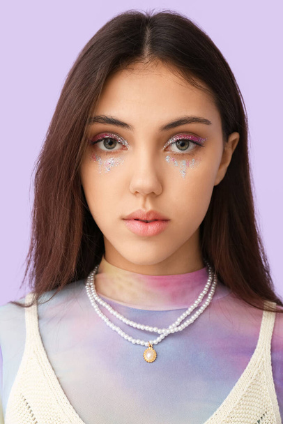 Portrait of young fashionable woman with creative makeup on color background - Photo, Image