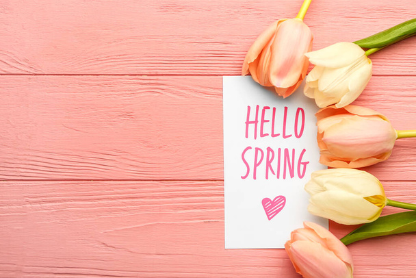 Carte avec texte HELLO SPRING et belles fleurs de tulipes sur fond en bois de couleur, gros plan - Photo, image