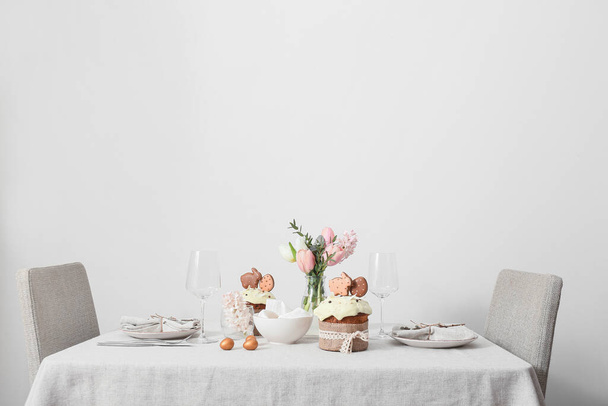 Table avec beau décor de Pâques près du mur de lumière - Photo, image