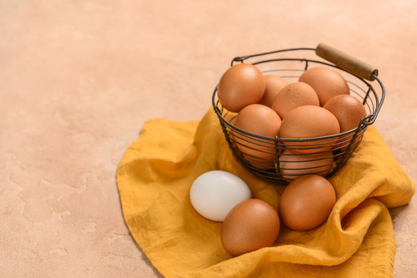 Cesta con huevos de pollo frescos sobre fondo beige - Foto, Imagen