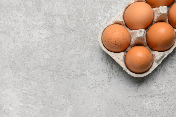Holder with fresh chicken eggs on grey background, closeup - Φωτογραφία, εικόνα