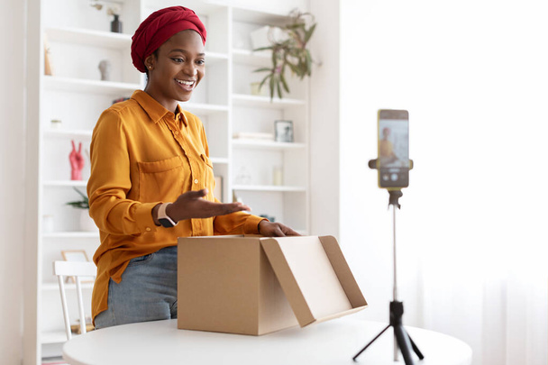 Female blogger shooting video while opening delivery box - Foto, Imagem