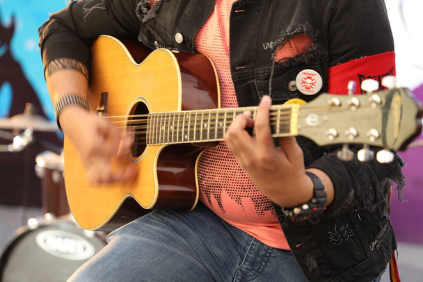 Музикант з гітарою на сцені - Фото, зображення