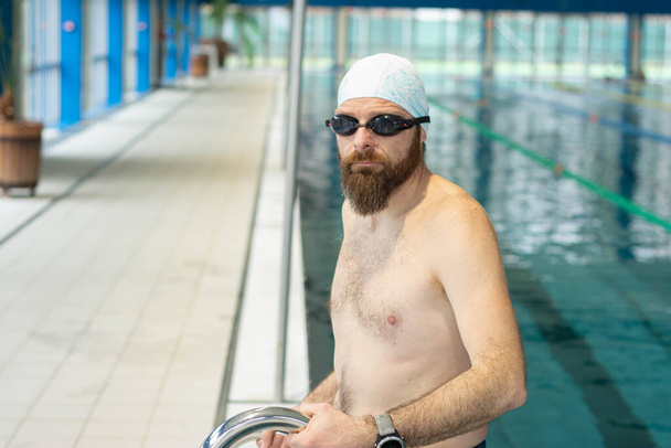 Portret van een zwemmer op de achtergrond van het zwembad - Foto, afbeelding