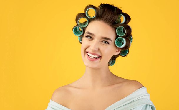 Portrait Of Cheerful Woman With Hair Curlers Posing, Yellow Background - Valokuva, kuva