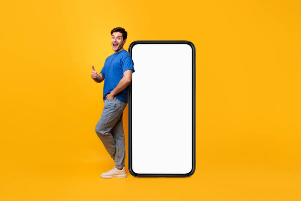 Man leaning on white blank smartphone screen showing thumbs up - Foto, Bild