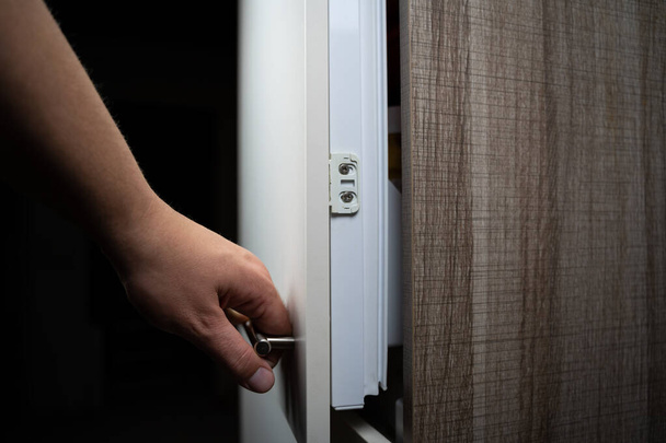 Hand opens the fridge at night - Фото, зображення