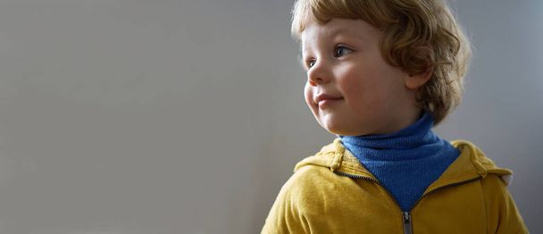 Little Ukrainian child smiling. He is wearing blue and yellow clothes - Foto, Imagen